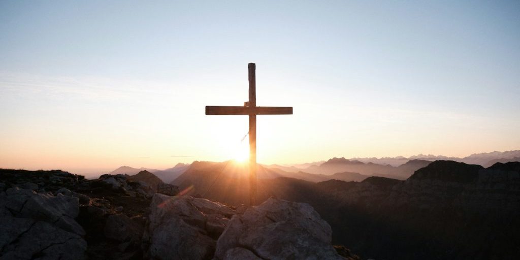photo by yannick pulver brown cross on brown rock during daytime
